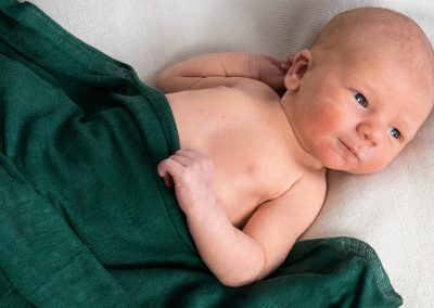Baby in green blanket laying down